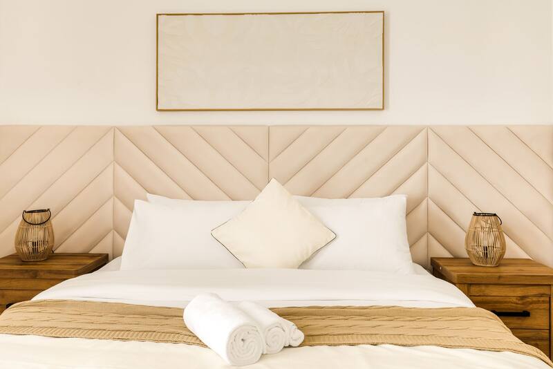 King bed made up with white linens and rolled towels